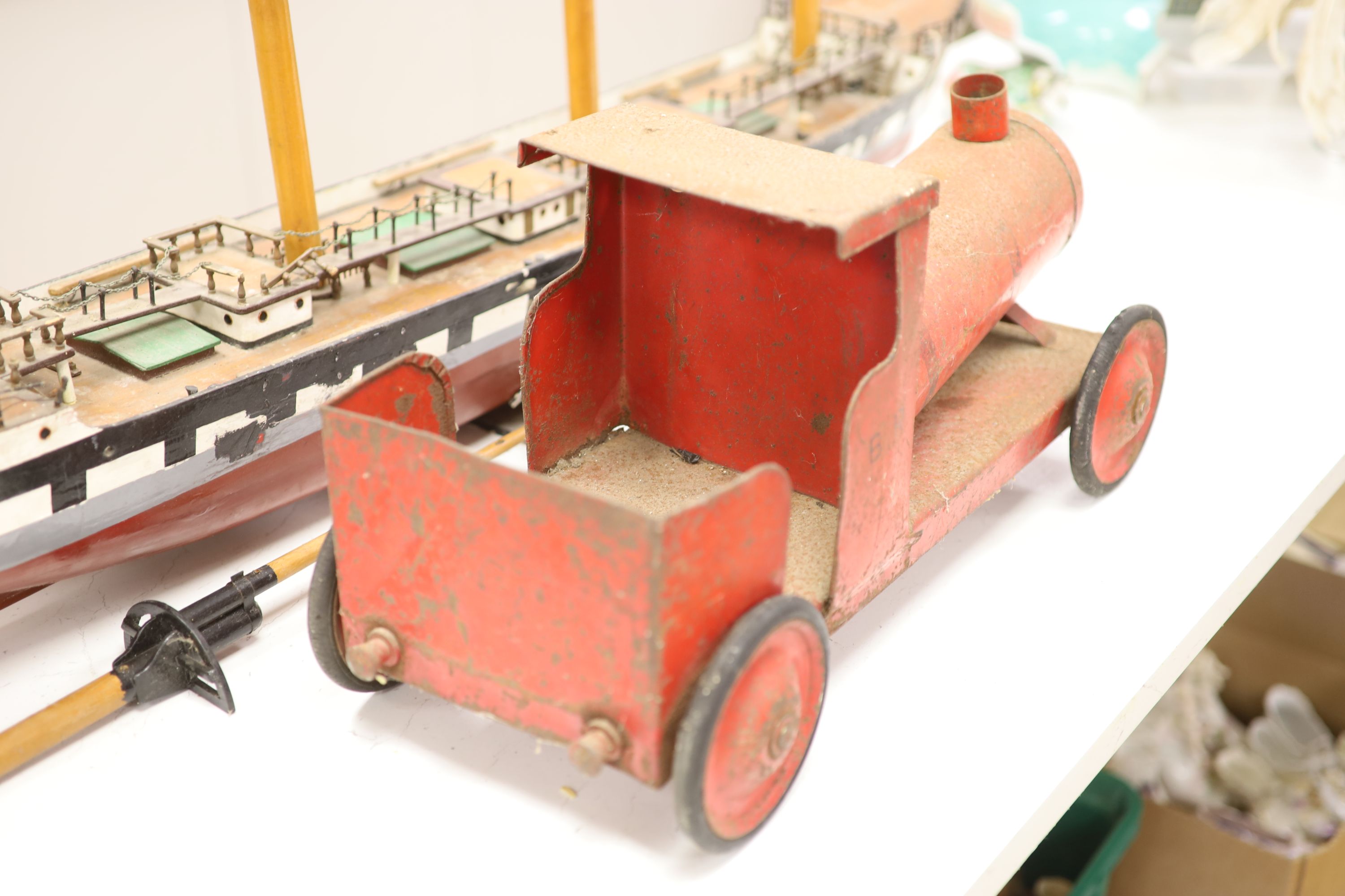 A scratch built primitive model of a cutter and an enamelled metal model of a locomotive, longest 137cm